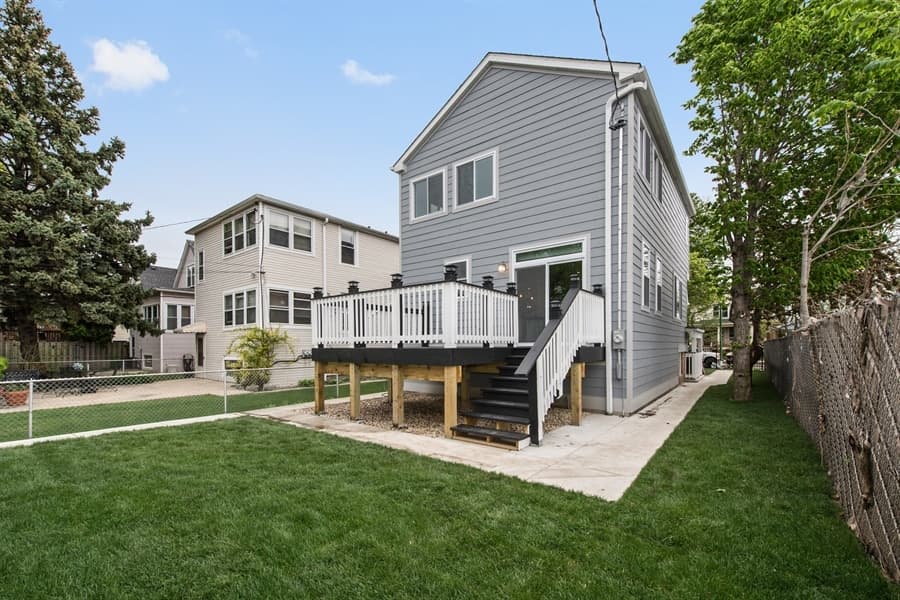 Rear of a two-storey home with a new deck and stairs