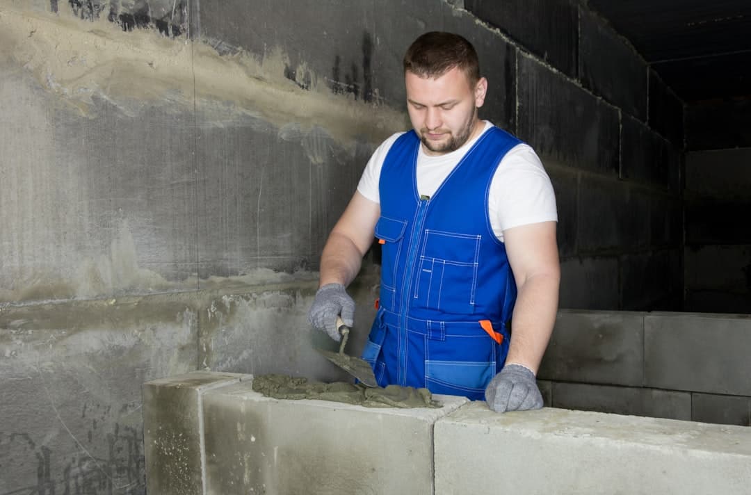 mason applying fresh mortar in mild spring weather