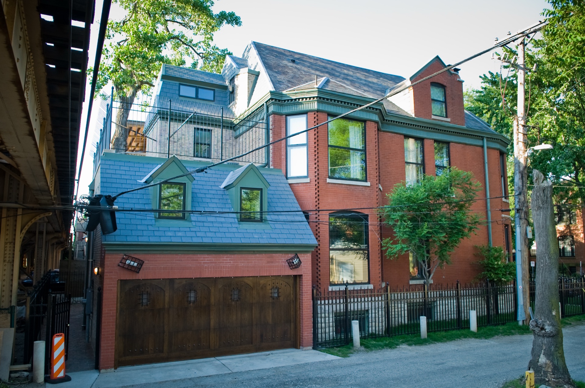 New two-storey home addition with a garage beside a brick Victorian home